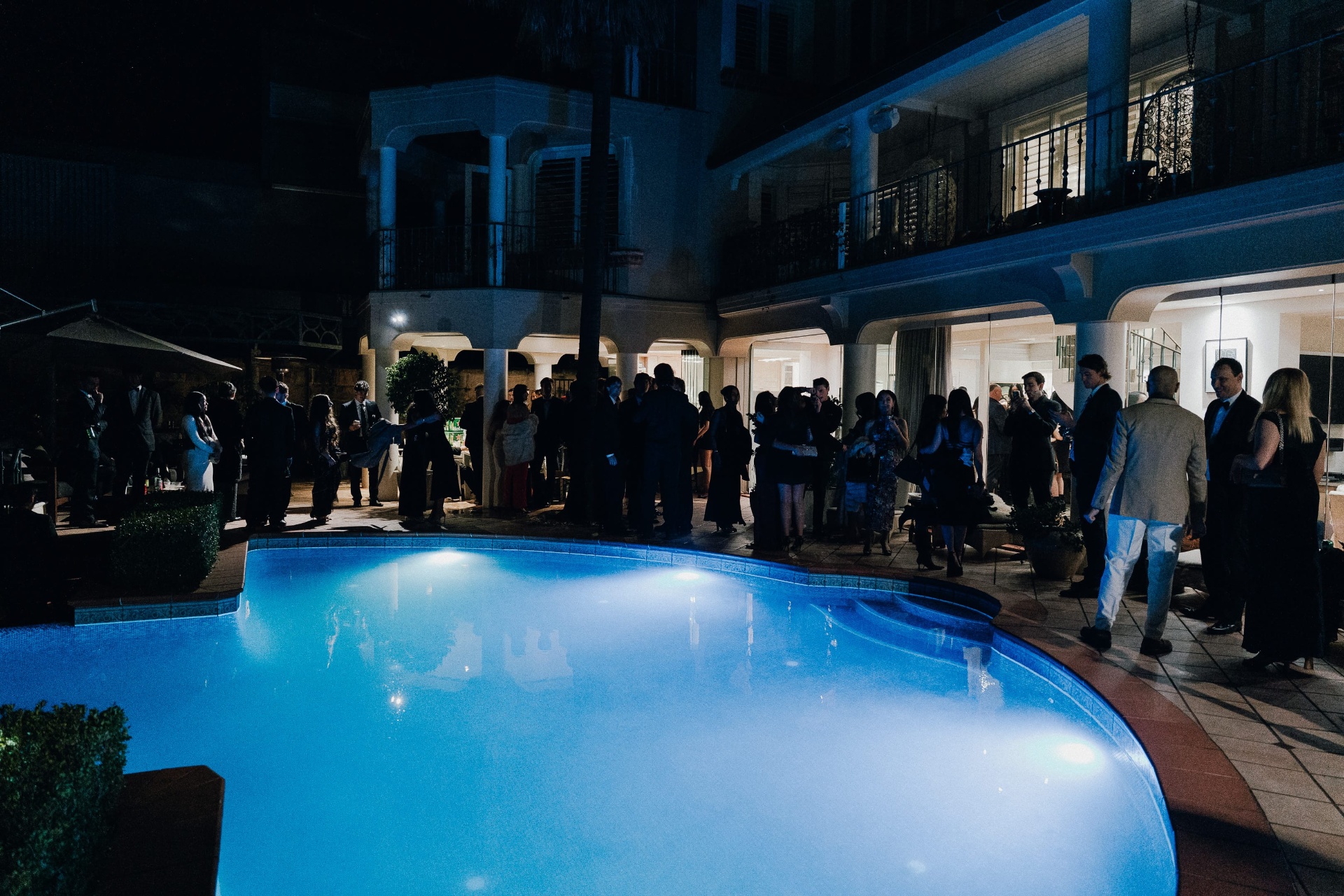 Two guests on the dock at night, house behind